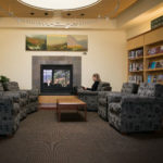 library patron reading in front of fireplace
