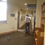 man vacuuming library hallway