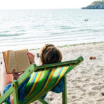 person on a beach reading a book