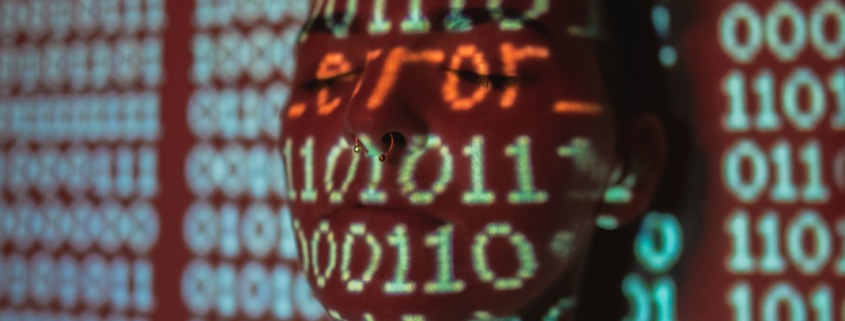 Man with word "error" and zeroes and ones projected over his face.Photo by Jayson Hinrichsen on Unsplash