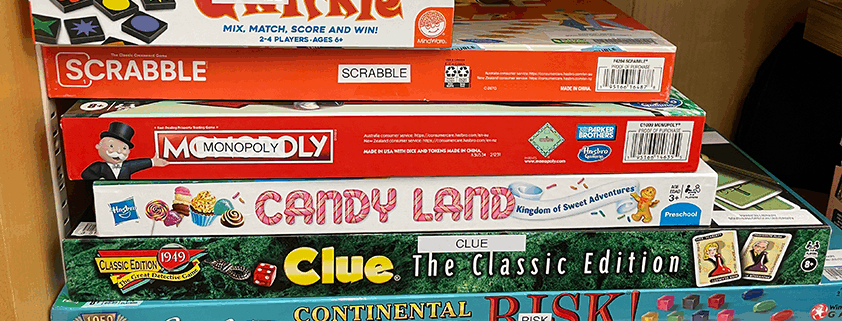 Stack of games such as Candy Land, Clue, and Risk