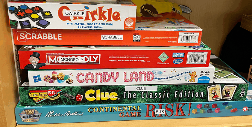 Stack of games such as Candy Land, Clue, and Risk