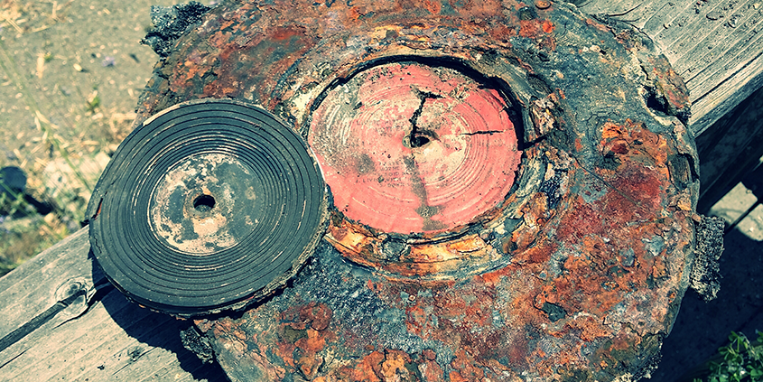 Melted vinyl record resting on fire-damaged turn table